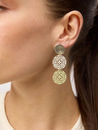 Close view of an ear wearing the three-tier filigree disc earring in Green