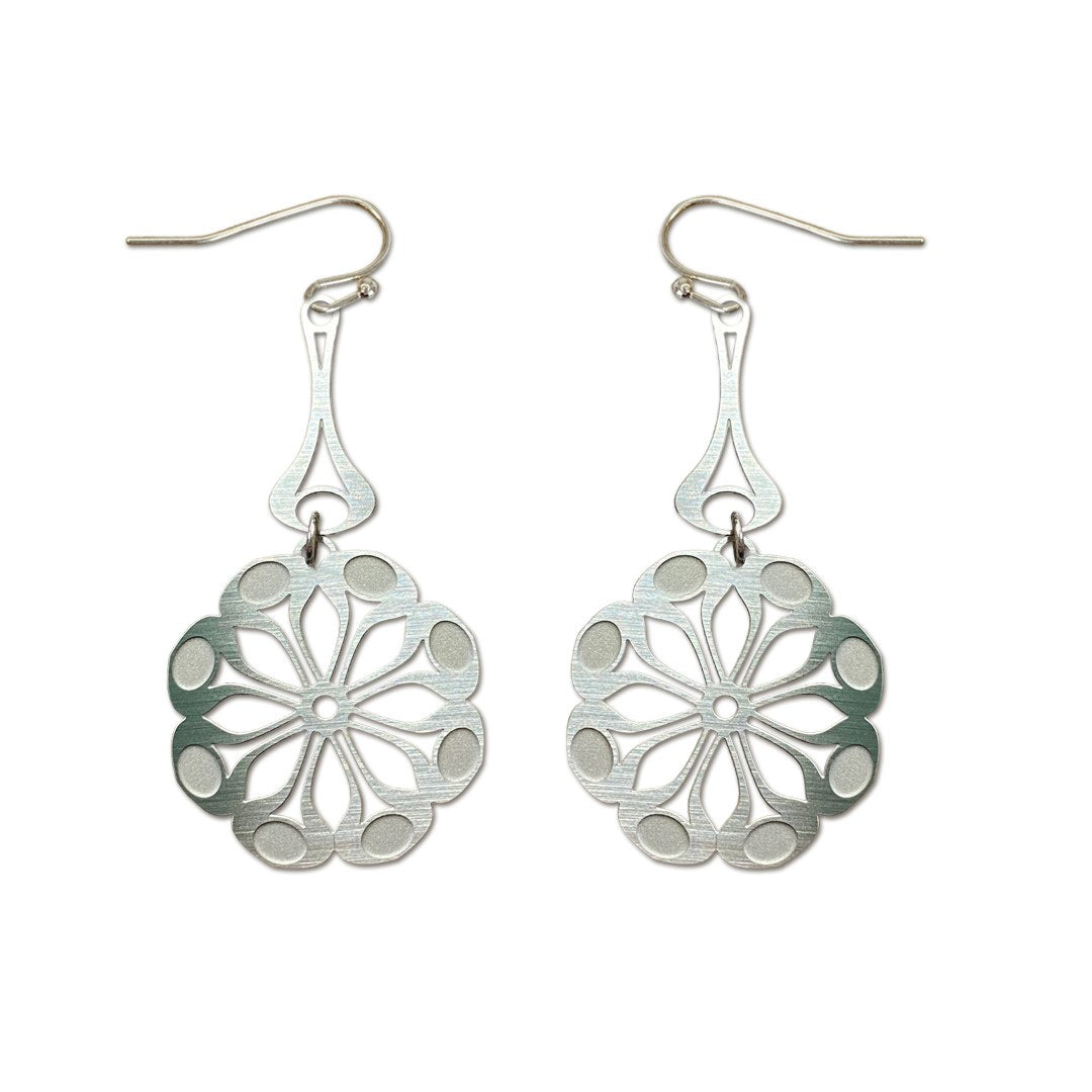 The Tribe earrings on white: silver steel flower medallions hanging from long drops.