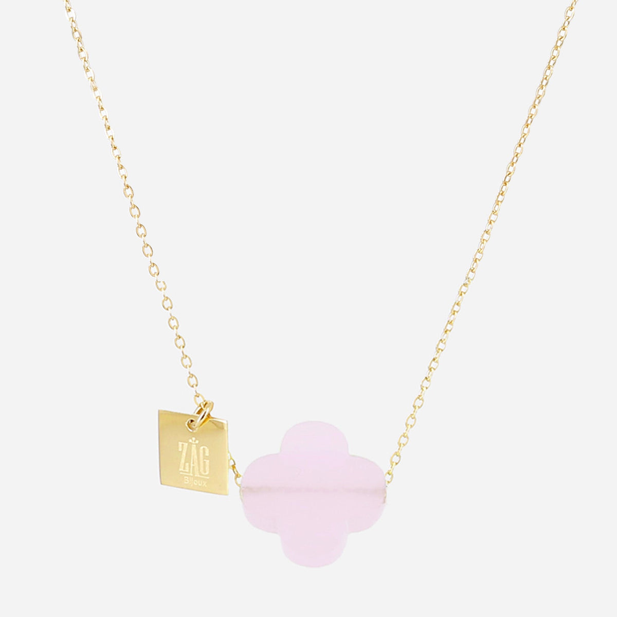 Fine gold chain necklace with a pale pink glass four-leaf clover and a square gold Zag tag.