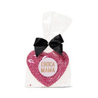 Milk chocolate heart covered in pink sprinkles in a clear cello bag with a black satin bow and a round pale pink Chocamama label