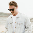 A man wearing the Dalton sunglasses, looking down and to the side