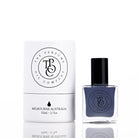 The Perfume Oil Company white gift cylinder beside a deep navy-blue 10 ml bottle of perfume oil