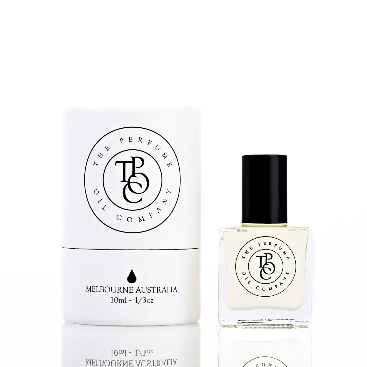 The Perfume Oil Company white gift cylinder beside a 10 ml bottle of perfume oil with a soft golden tint