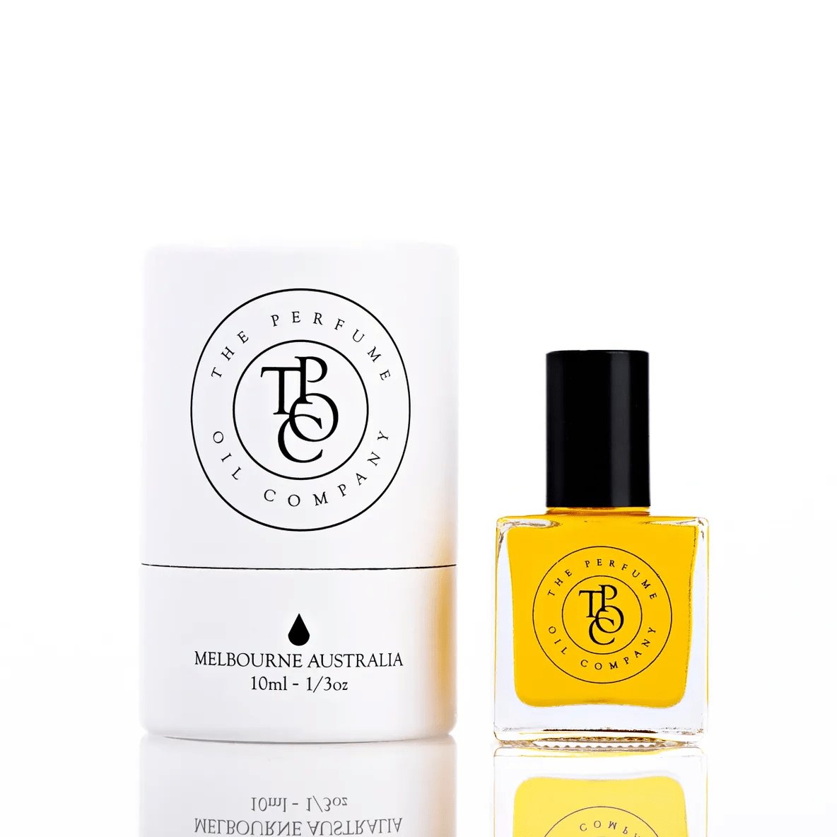 The Perfume Oil Company white gift cylinder beside a 10 ml bottle of rich golden-yellow perfume oil
