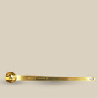 Long gold tea spoon engraved with The Tea Collective branding