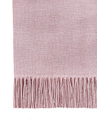 Close-up of the blush throw showing its soft dusty pink weave and long fringe