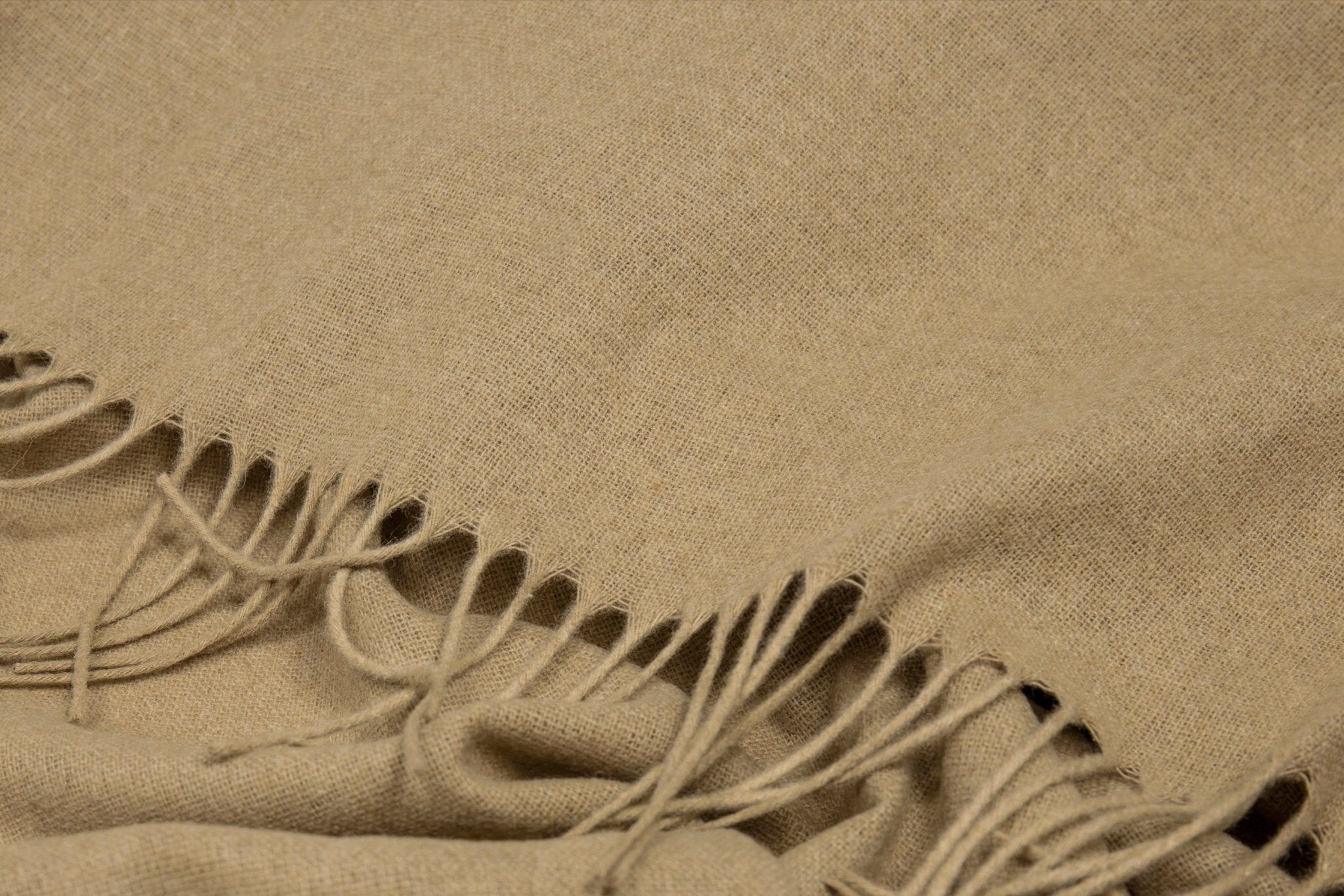 Close-up of the camel throw's fringe and soft flecked weave