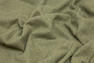 Close-up of the olive throw's soft draped weave showing its flecked wool texture