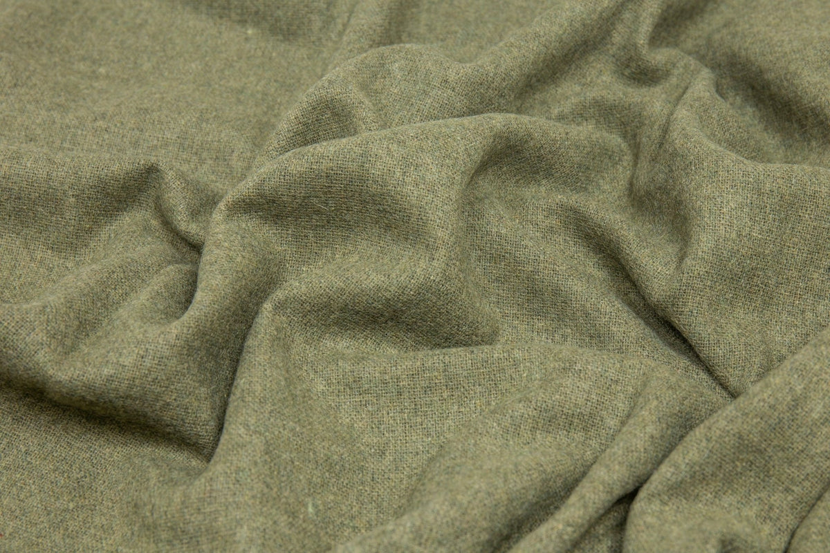Close-up of the olive throw's soft draped weave showing its flecked wool texture