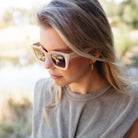 A woman with blonde hair in profile wearing the Zahra sunglasses